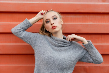 Model pointing upwards in studio and looking at camera