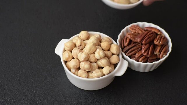 Delicious nutritious hazelnut in ceramic bowl on dark concrete background