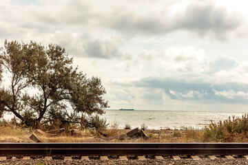 A train tracks are seen next to a body of water