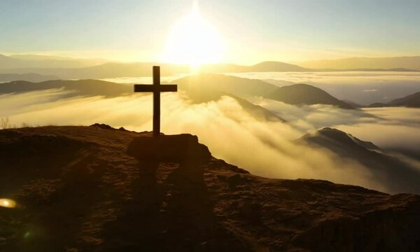 Silhouette of a cross on the hill of Golgotha, sunrise, sunset sky background. Copy space. Ascension Day concept. Christian Easter.  Christianity.