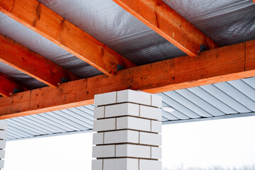 The structure features a brick chimney that is positioned beneath a roof supported by sturdy wooden...