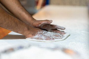 Chef's hands spraying flour over the dough. Kneading dough. chef kitchen dough