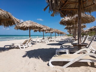 Empty sand beach, sunbeds, straw umbrellas in Varadero, Cuba, no people
