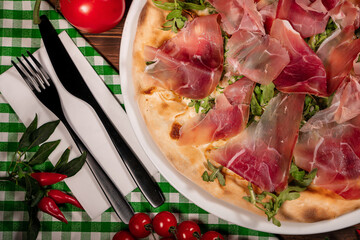 White pizza with prosciutto crudo, arugula and parmesan