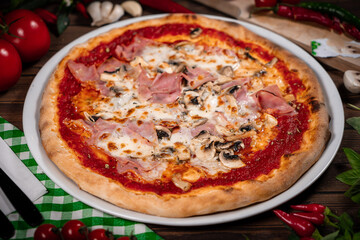 Pizza capricciosa with cooked ham, mozzarella on wooden table