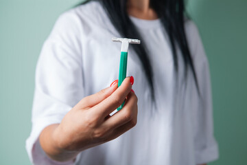 close up of young female hands with a razor