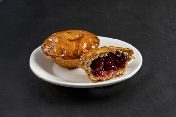 Shortbread tart with berries and fruits on a dark background close-up
