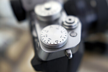 A close-up macro photograph of a camera's control dial camera settings exposure compensation, aperture, shutter speed, ISO, settings, manual controls