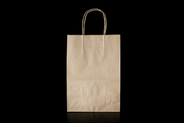 Recyclable craft paper bag for purchases, gifts and takeaway food mock up on black background. Environmentally friendly than single-use plastic bags
