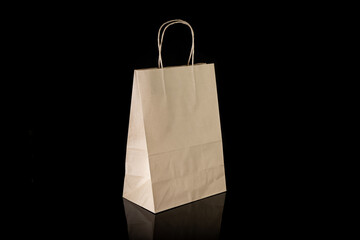 Recyclable craft paper bag for purchases, gifts and takeaway food mock up on black background. Environmentally friendly than single-use plastic bags