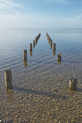 Wooden signposts in the shallow water of the clear sea as indicator