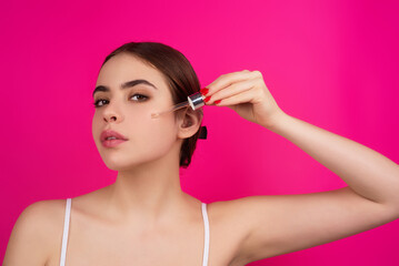 Woman, dropper and facial skincare cosmetics for beauty, hydration or oil treatment for healthy face. Closeup of female beauty model applying serum to cheek for skin hydrate, glow or shine.