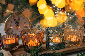 Christmas decor with candles. Wooden tray with burning candles and christmas decorations on with warm plaid. Winter cozy style. Hygge concept