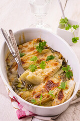 Traditional Italian chicory gratinated with buffalo mozzorella and herbs served as closeup in a classical backing form