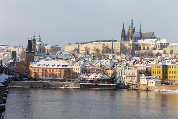 Fototapeta premium Snowy Prague Lesser Town with Prague Castle above River Vltava, Czech republic 