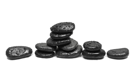 Spa oval black stones with drops, isolated on white background, side view