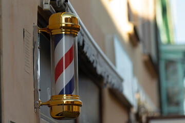 An exceptionally crafted barber pole light fixture has been artistically installed on an exterior wall in city
