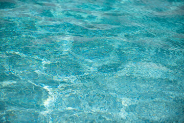 Ripple Water in swimming pool with sun reflection. Wavy water background.