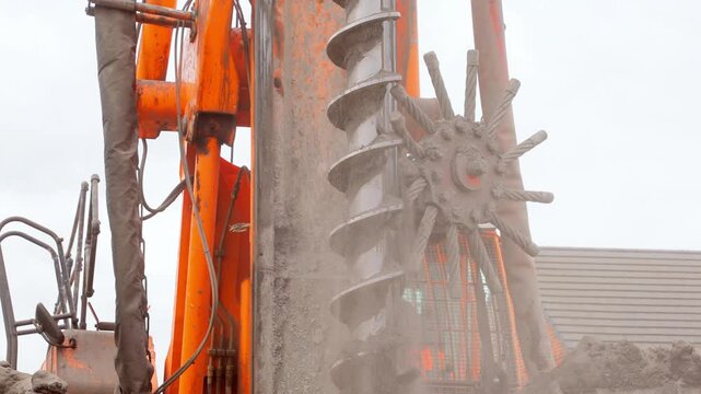 Heavy machinery Piling rig auger drills deep into ground at construction site in urban area