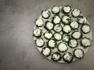 Christmas appetizer with cream cheese and dill on cucumber slices in prague party food for aperitif, New Year's Eve dinner, Christmas or birthday