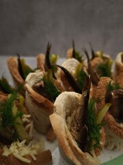 Christmas appetizers featuring smoked fish, pickles, and dill on toasted bread cups in prague party food for aperitif, New Year's Eve dinner, Christmas or birthday