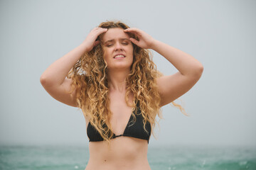 Young Woman with curly hair in a Bikini by the Ocean