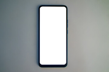 Modern smartphone on a plain surface with blank screen ready for use
