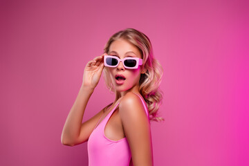 Photo of pretty young girl model amazed reaction touching sunglass dressed bodysuit isolated on pink color background