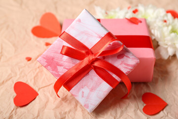 Gift boxes with white chrysanthemum flowers and hearts on crumpled paper. Valentine's Day celebration