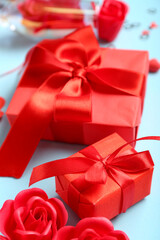 Gift boxes and red roses on blue background. Valentine's Day celebration