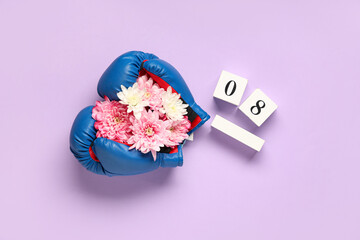 Composition with boxing gloves, flowers and calendar with date of International Women's Day on lilac background