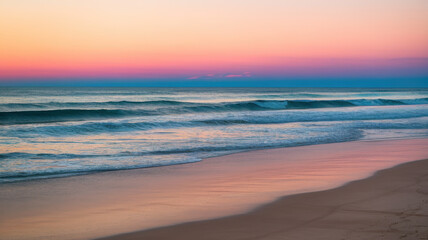 A serene beach scene at sunset, featuring gentle waves lapping at the shore under a gradient of pastel pink and blue skies.