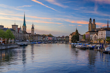 Fototapeta premium Cityscape of Zurich, Switzerland, at dusk. Buildings on the banks of the Limmat River flowing through Altstadt city center, boats along the waterfront