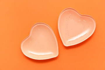 Beautiful heart-shaped plates on orange background