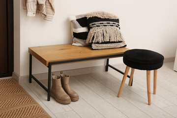 Bench with pillows, stool and boots in hallway