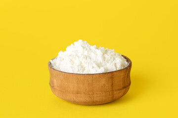 Bowl of white powder pigment on yellow background