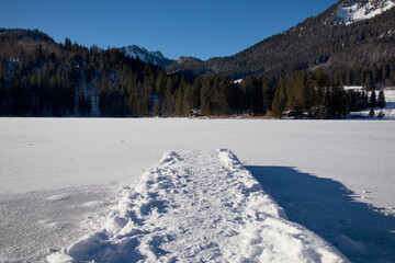 Steg im winter über einem See mit Schnee und Eis