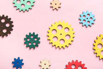 Wooden gears on pink background