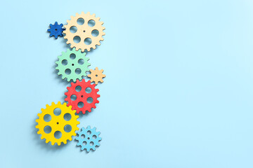 Wooden gears on light blue background