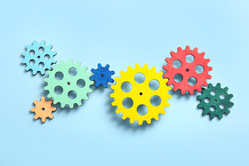 Wooden gears on light blue background