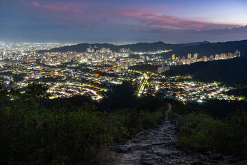 City lights illuminating Valencia, Venezuela, as seen from Casupo mountain during blue hour at dusk, creating a majestic urban nightscape. Cityscape concept.