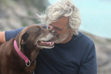 portrait of a senior man bonding with his dog outdoors