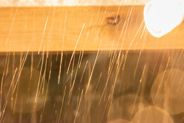 Snowing in the night lightened by yellow light
