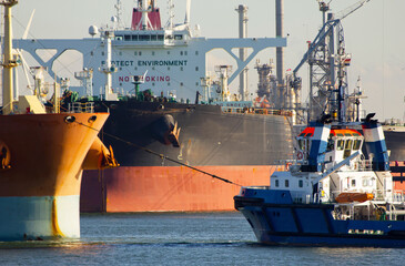 Aerial view of a tugboat and a large oil tanker in the port of Rotterdam