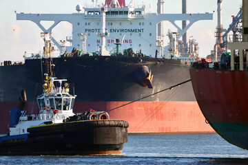 Aerial view of a tugboat and a large oil tanker in the port of Rotterdam
