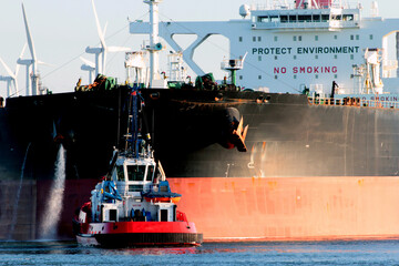 Aerial view of a tugboat and a large oil tanker in the port of Rotterdam