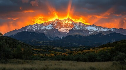 Stunning sunset over a snow-capped mountain range with dramatic light rays.