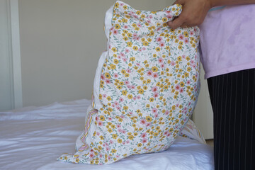 Woman Puts Pillow Into Pillowcase.