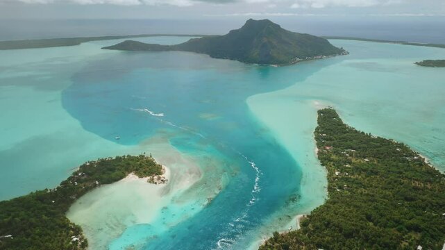 Aerial view Maupiti island in French Polynesia, turquoise water lagoon ocean channel, lush green vegetation, speedboat, mount Teurafaatui. Remote wild nature paradise, exotic summer travel background