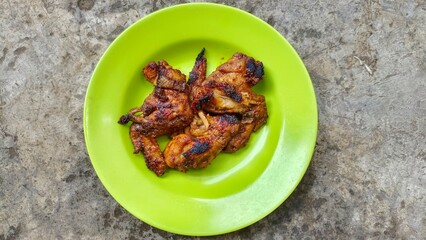 Grilled chicken served on a green plate